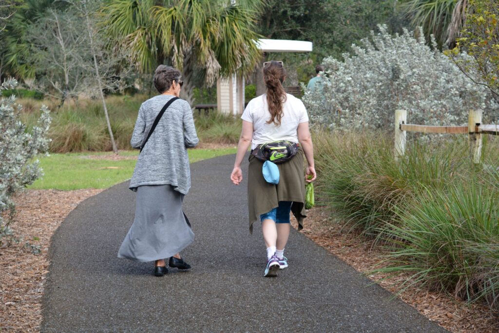 women walking path park amidst trees