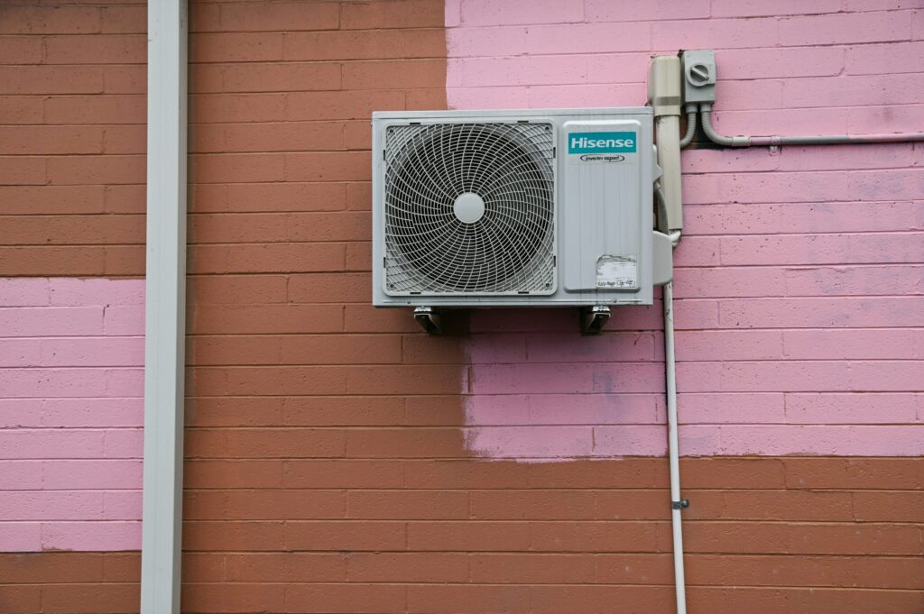 Wall-mounted air conditioning unit on Perth rental property exterior for summer maintenance