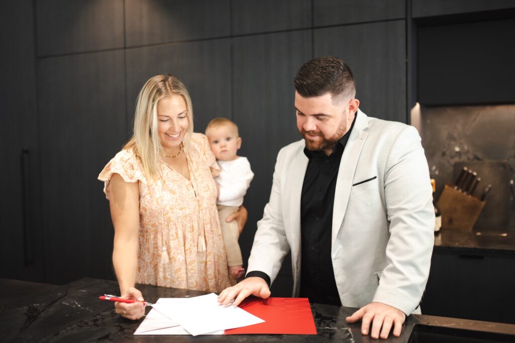 Semple Property Group agent helping a client review paperwork in a modern kitchen, showcasing professional property management and personalised service.