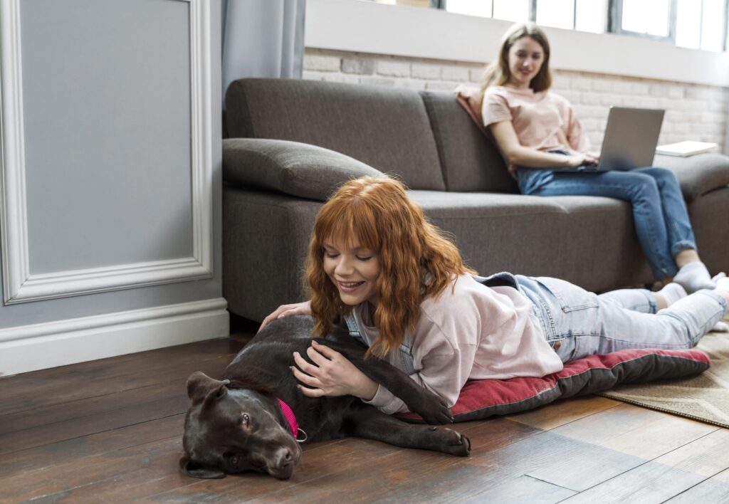 Young woman playing with their family dog inside their rental property in Perth