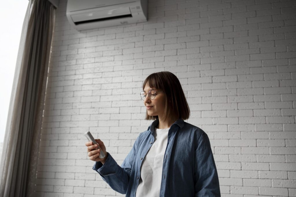 Young renter turning on the air conditioning unit in their rental property in Perth