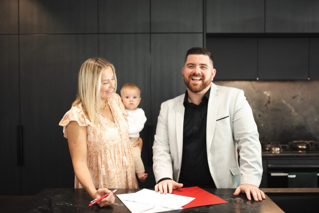 Semple Property Group property manager assisting a young family with their rental paperwork in a modern Perth home