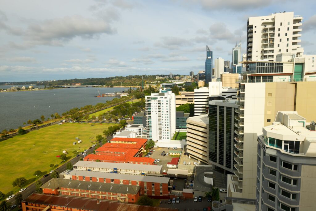 High-rise apartment buildings in Perth overlooking Swan River and CBD skyline, showcasing urban investment properties and units in demand