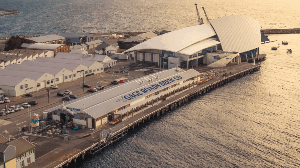 Aerial view of Gage Roads Brew Co on Fremantle Harbour at sunset, showcasing waterfront dining and historic port buildings.