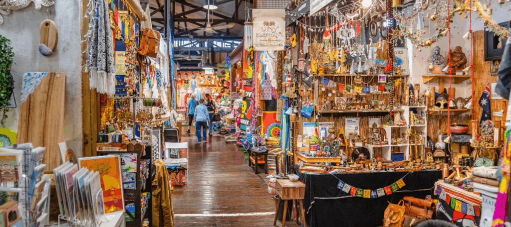 Inside Fremantle Markets featuring colourful artisan stalls, handmade gifts, local crafts and shoppers exploring the historic indoor market.