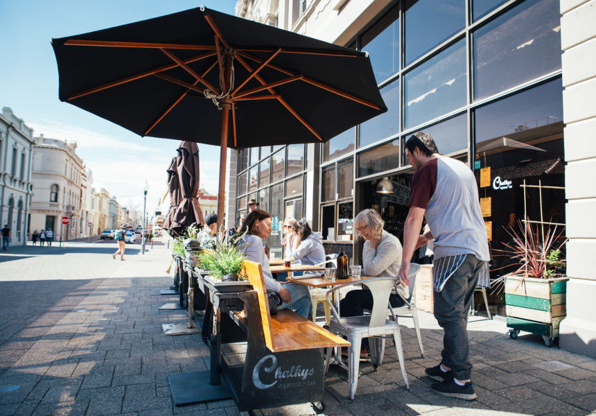 Outdoor dining at Chalky’s Espresso Bar in Fremantle with people seated under umbrellas on a sunny street corner.